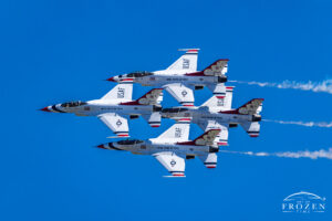 An aviation art print featuring the USAF Thunderbirds in a tight diamond formation passing through the clear blue Columbus skies