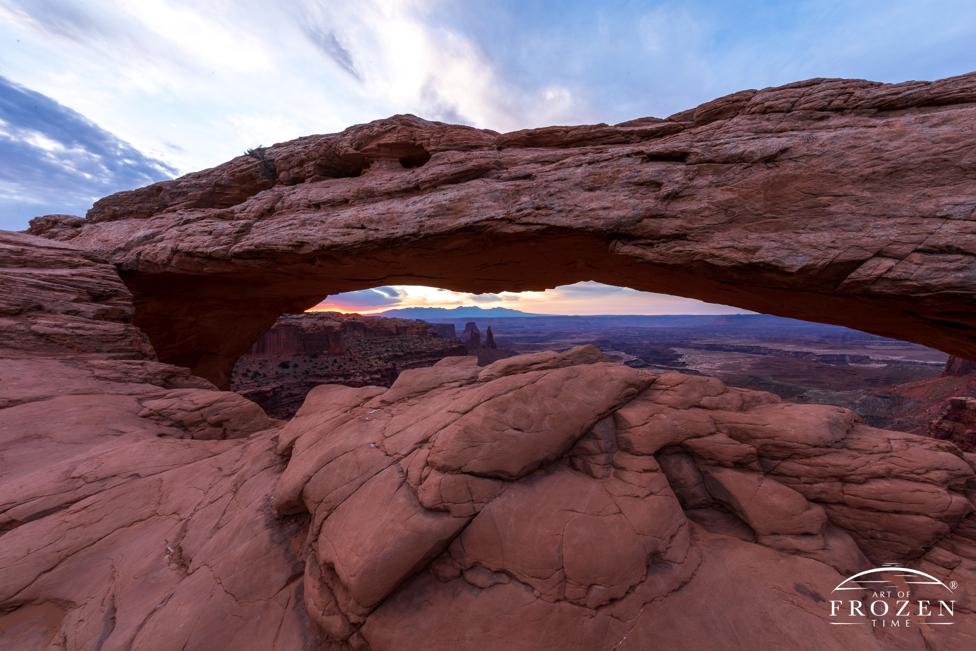 A dim view of sunrise at Mesa Arch where clouds blocked the sunlight, giving the scene a colder feeling