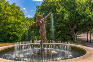 A graceful sculpture titled the Muse of Clifton stands in Burnet Woods on a summer day where water streams from her open palms.