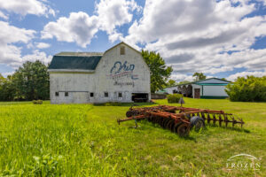 A white double bay barn featuring the Ohio Bicentennial Barn logo on its north side. Given its 25 years, the logo is beginning to fade, adding a nostalgic feeling to the farm