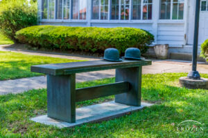 A bronze bench with two bowler hats, classically worn by the Wright Brothers, with words that pay tribute to their discovery of flight.