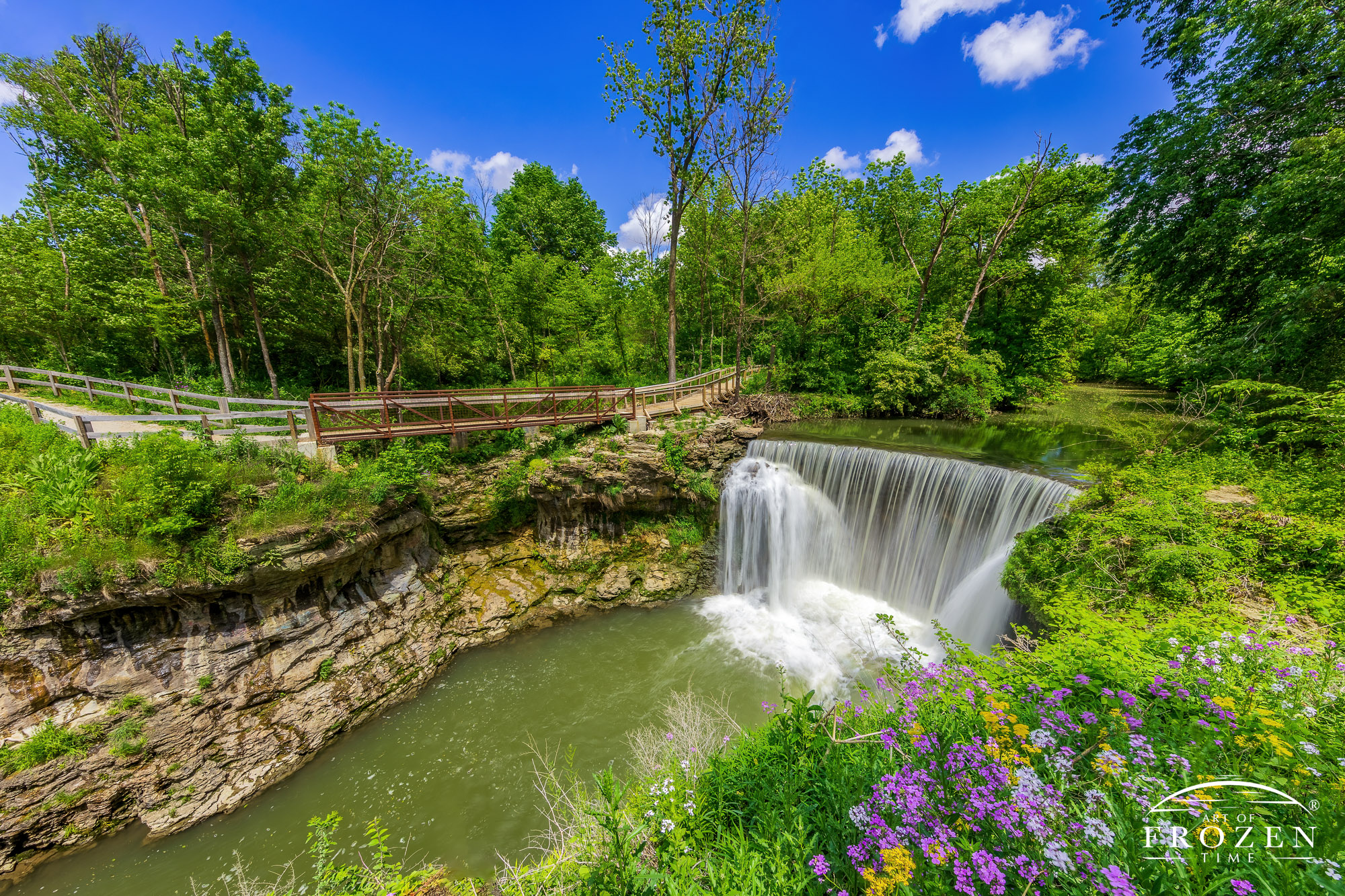 Cedar Cliff Falls near Cedarville waterfall on a perfect spring day where Ohio’s lush green vegetation surrounds Massie Creek as it spills into the gorge