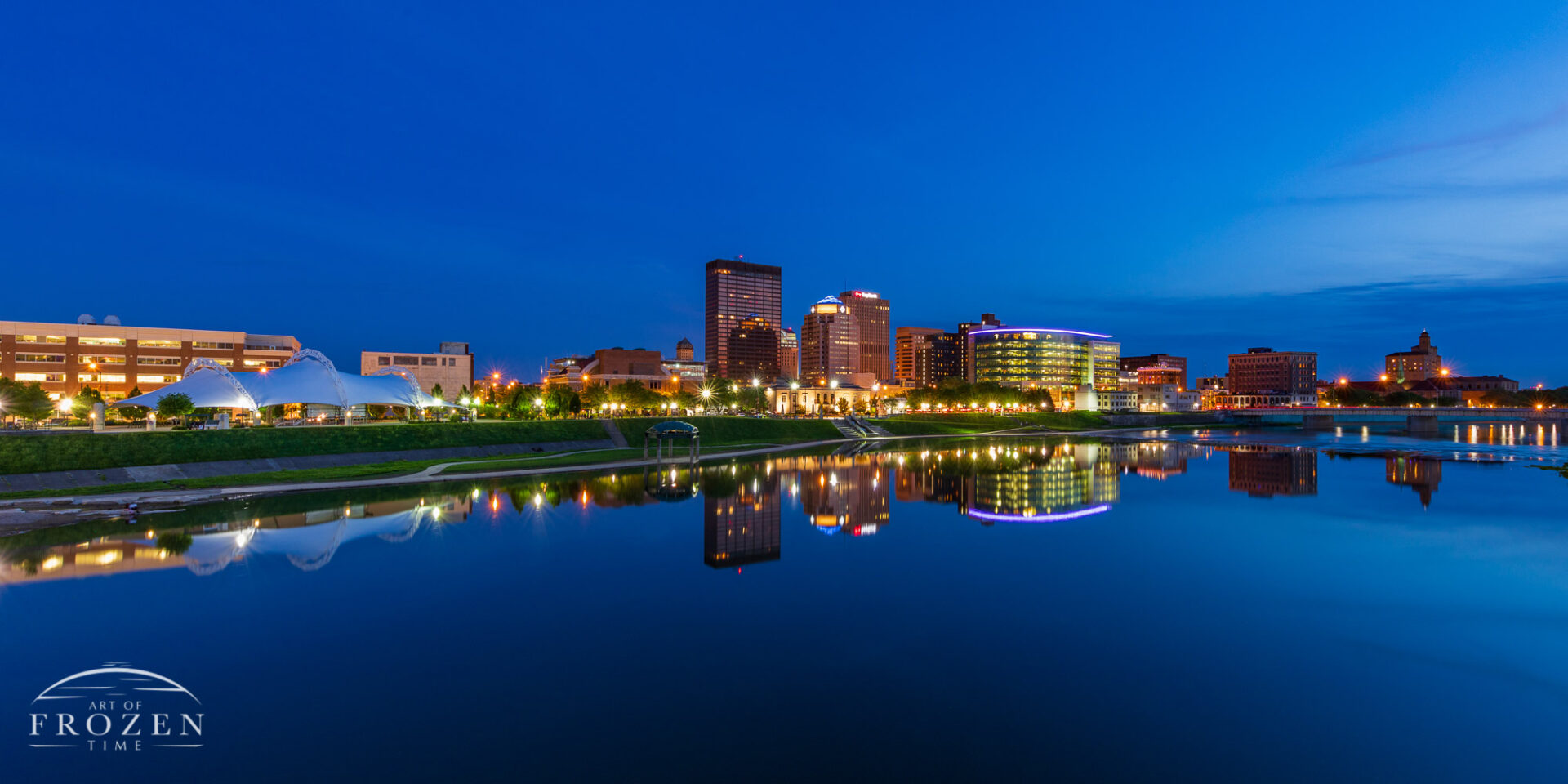 Dayton Skyline where the Miami River perfectly reflects the warm city lights which complements the deep blues of twilight