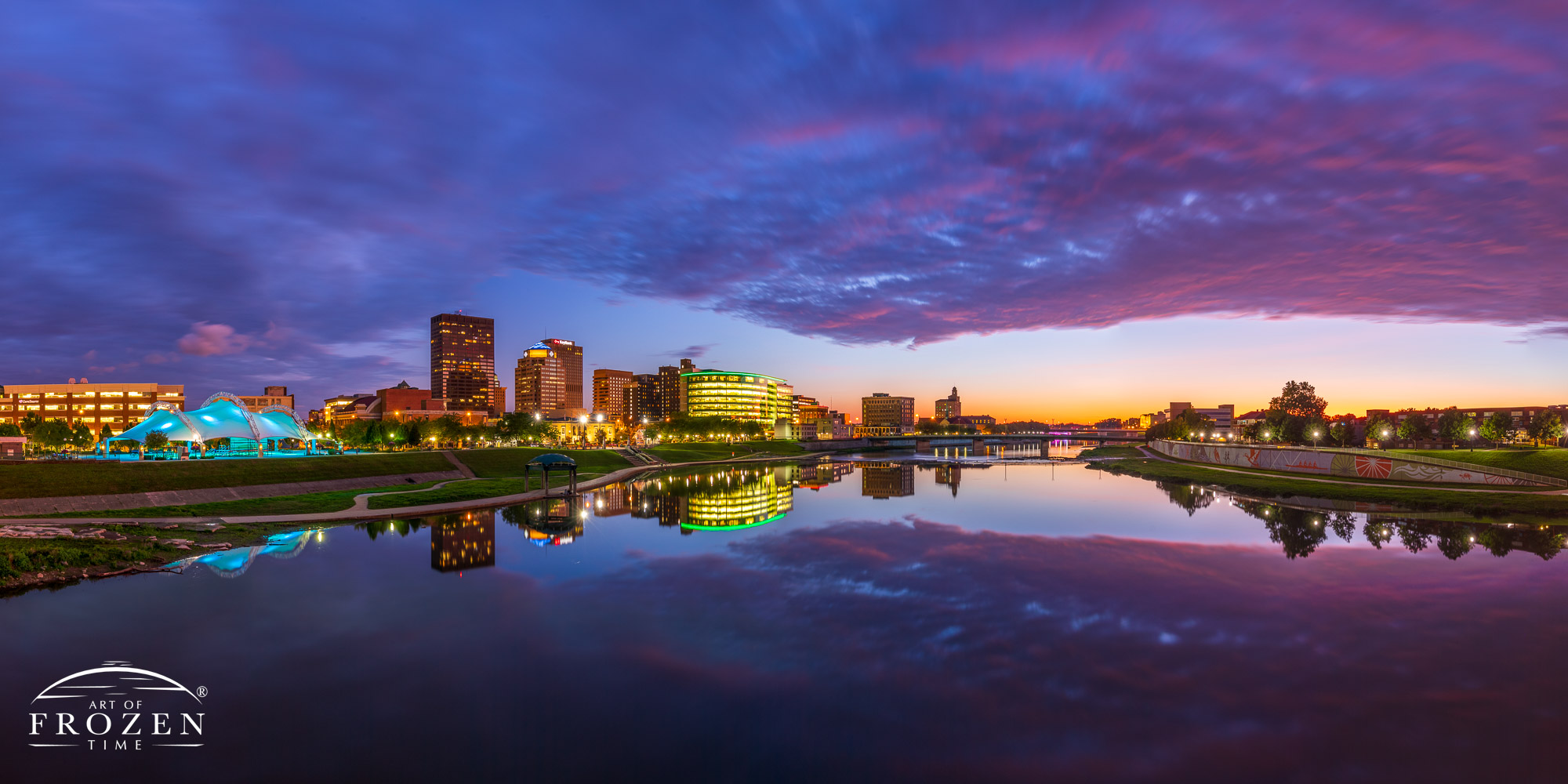 Dayton Skyline panorama at twilight as the Miami River reflects the city lights and pink and purple clouds