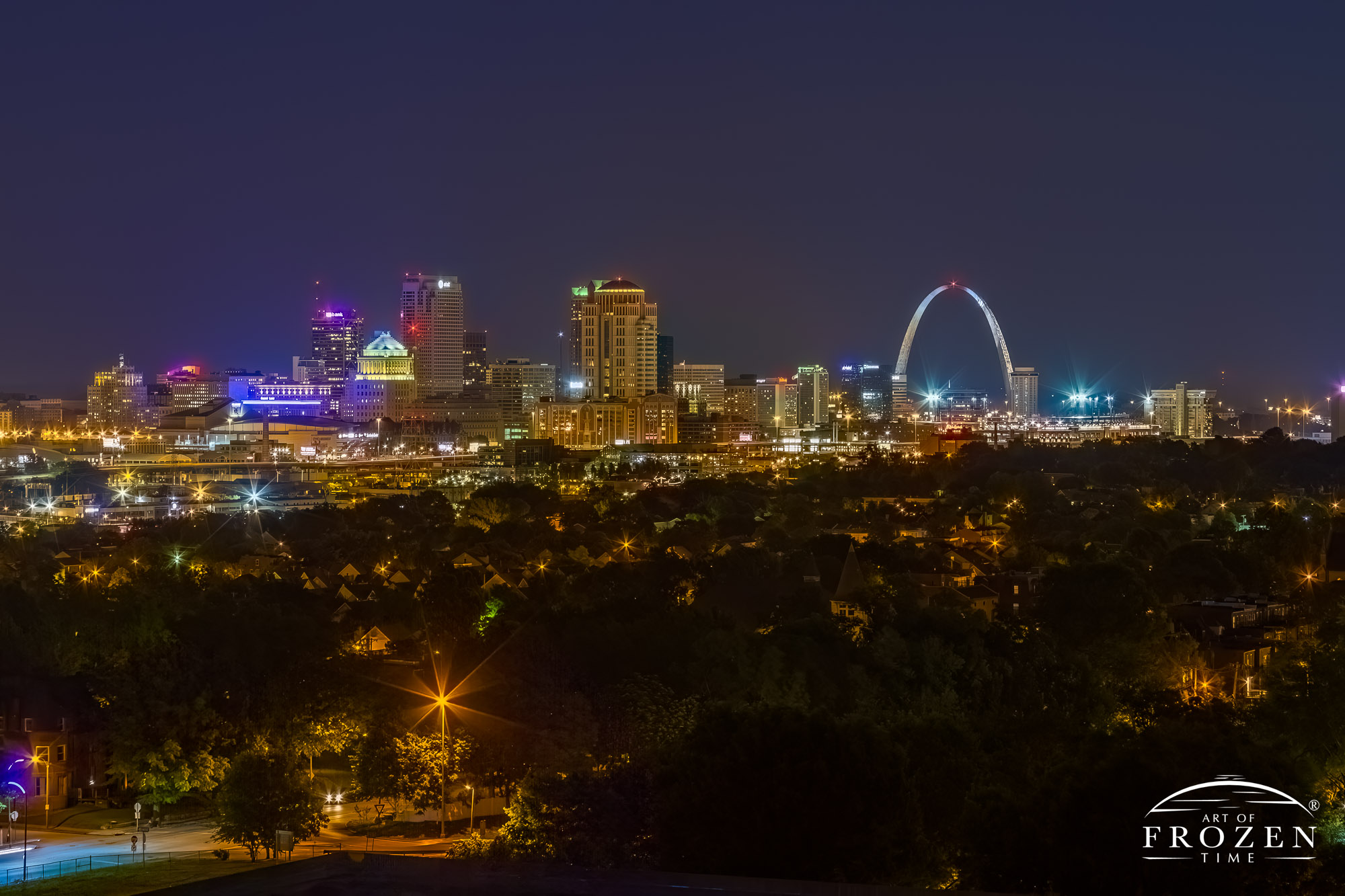 The St Louis Skyline from the west at night where distant office lights and uplighting on the Gateway Arch makes the city glow