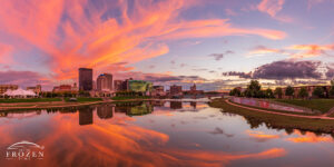 A Dayton Skyline panorama where orange cirrus clouds gently arch over the Miami Valley, while the Miami River reflects the cityscape
