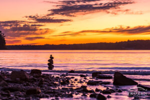 Peaceful twilight over this Caesar Creek State Park shoreline where gentle waves lap at a stack of rocks