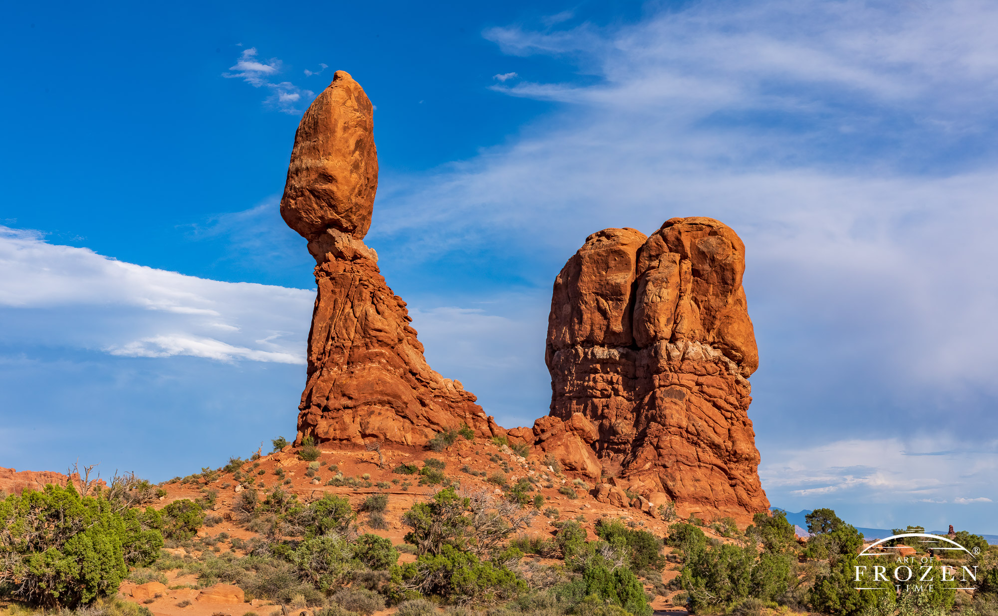 Balanced Rock in Arches National Park appears as a precariously balanced 55-foot red sandstone balanced on a 73-foot-high base rock.