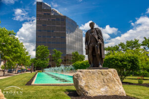 A bronze statue of George Rogers Clark in front of a long fountain in downtown Springfield Ohio