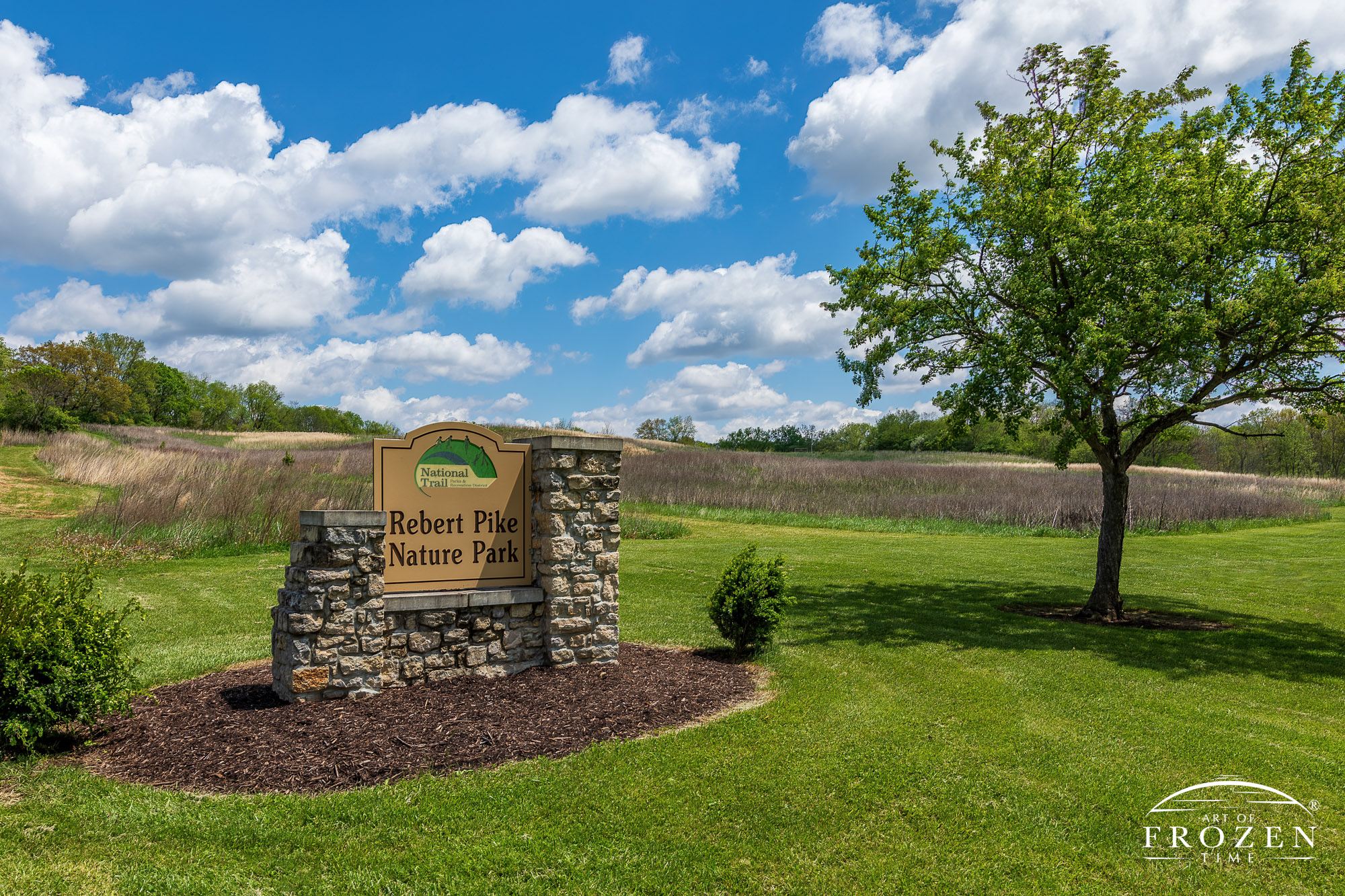 The Rebert Pike Nature Park entrance sign on a spring day under puffy clouds