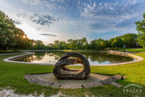 Dawn over Kettering Ohio’s Lincoln Park where the sun gently paints an intriguing stone sculpture in golden light