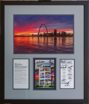 A framed print of a first day of issue stamp with signatures of attendees from the first-day ceremony matted with the original print of the St Louis Skyline