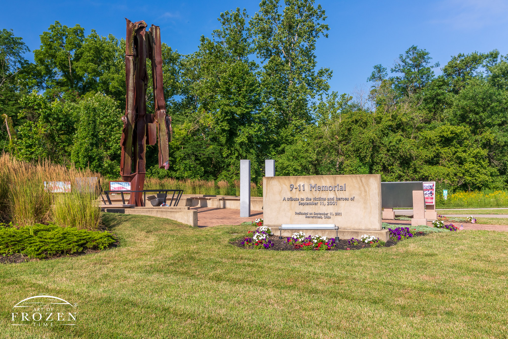 A Beavercreek Ohio 9/11 memorial featuring a 23-foot bent and sheared steel beam of the World Trade Center that sits among flowers and flags
