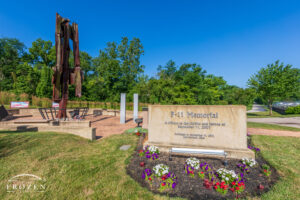 A Beavercreek Ohio 9/11 memorial featuring a 23-foot bent and sheared steel beam of the World Trade Center that sits among flowers and flags