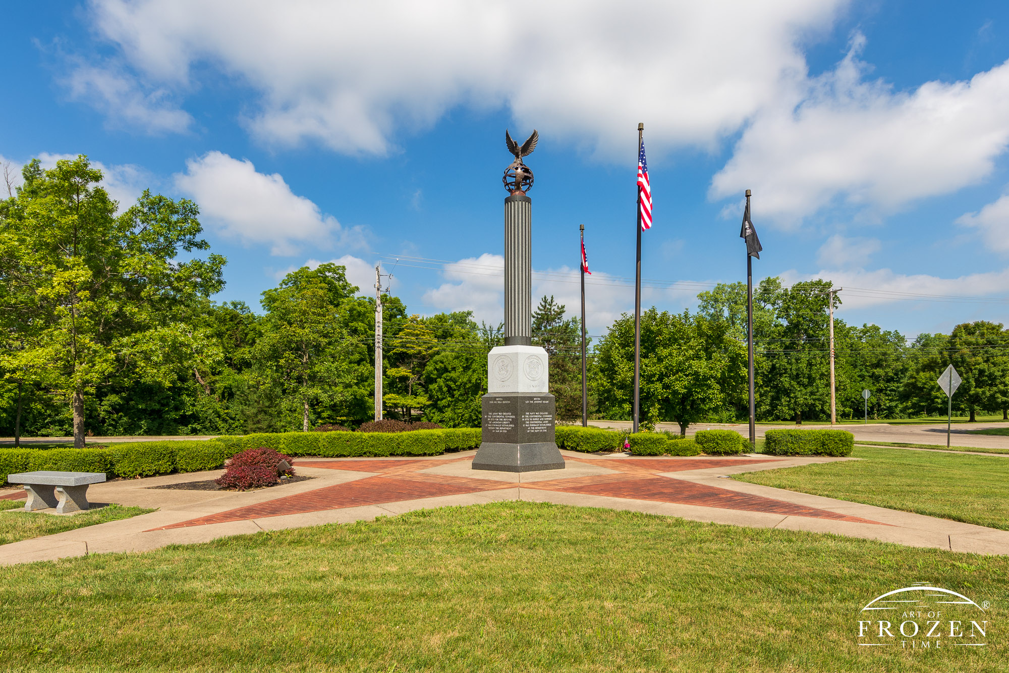 The Beavercreek Veterans Memorial on a sunny day with puffy clouds which honors local veterans from each of the five services