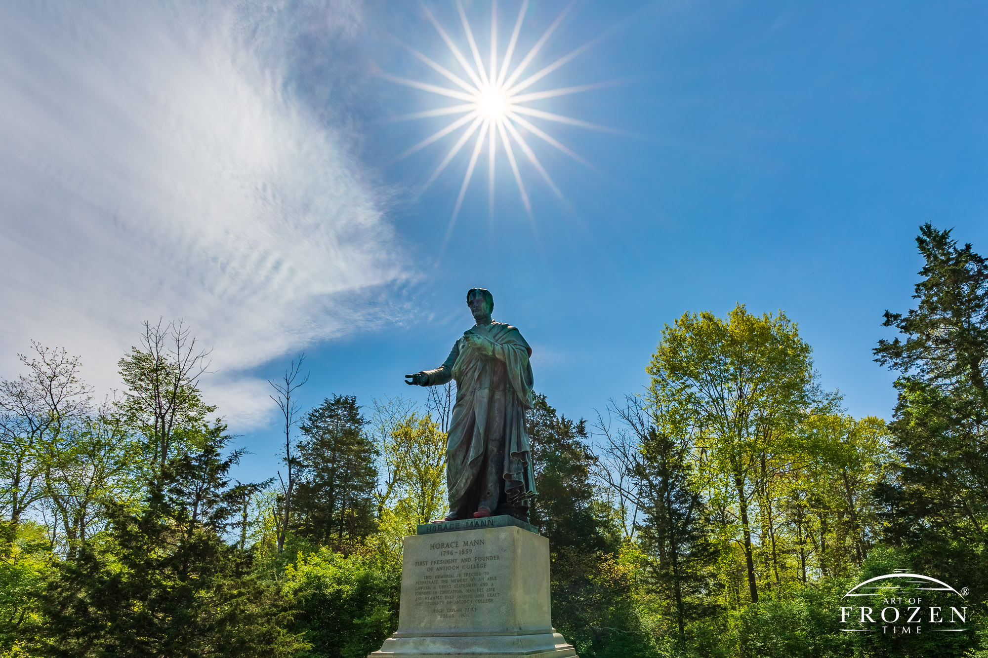 Horace Mann Monument on a sunny spring day where the sun is rendered as a starburst