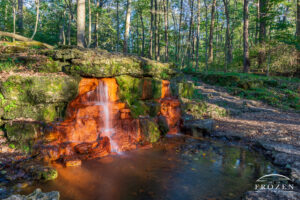 The Yellow Springs at sunset where sunlight warmly illuminates the waterfall just before sunset