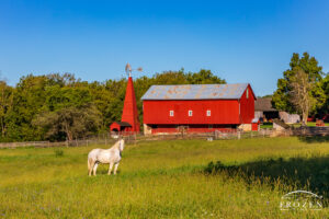 A classic bank barn and wooden windmill whose red paint contrast with the blue September skies