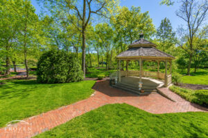 A large gazebo at Benham’s Grove stands among tall trees completing their spring leaf out