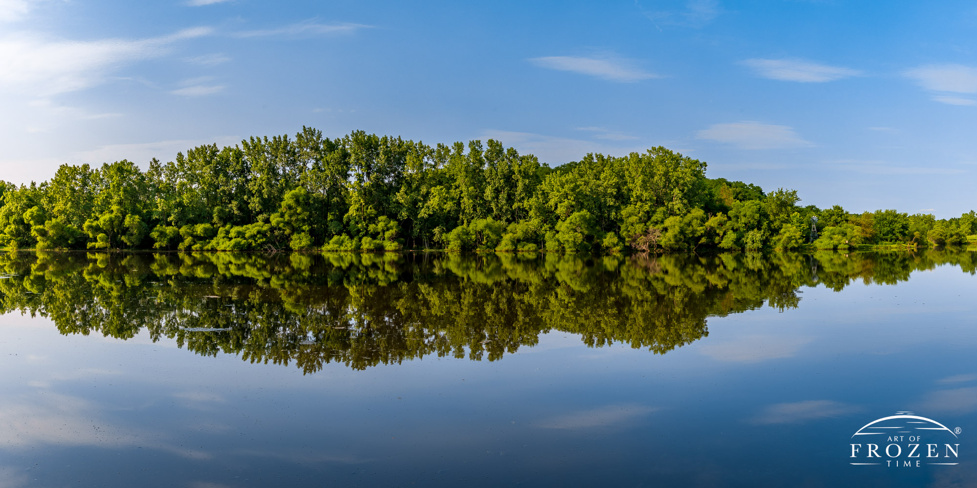 Carriage Hill MetroPark’s Cedar Lake perfectly reflects the distant shoreline on a still summer evening