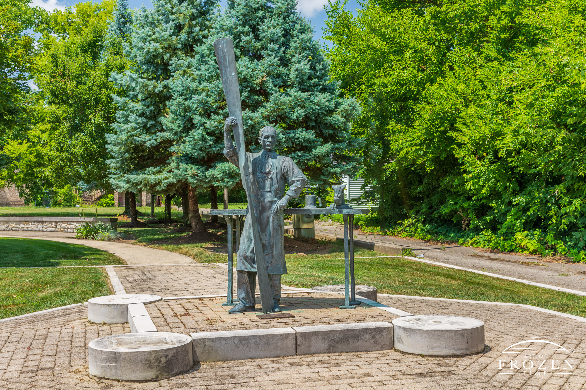 A bronze Wilbur Wright sculpture standing with an eight-foot propeller on the site of the former Wright Aeronautical Laboratory