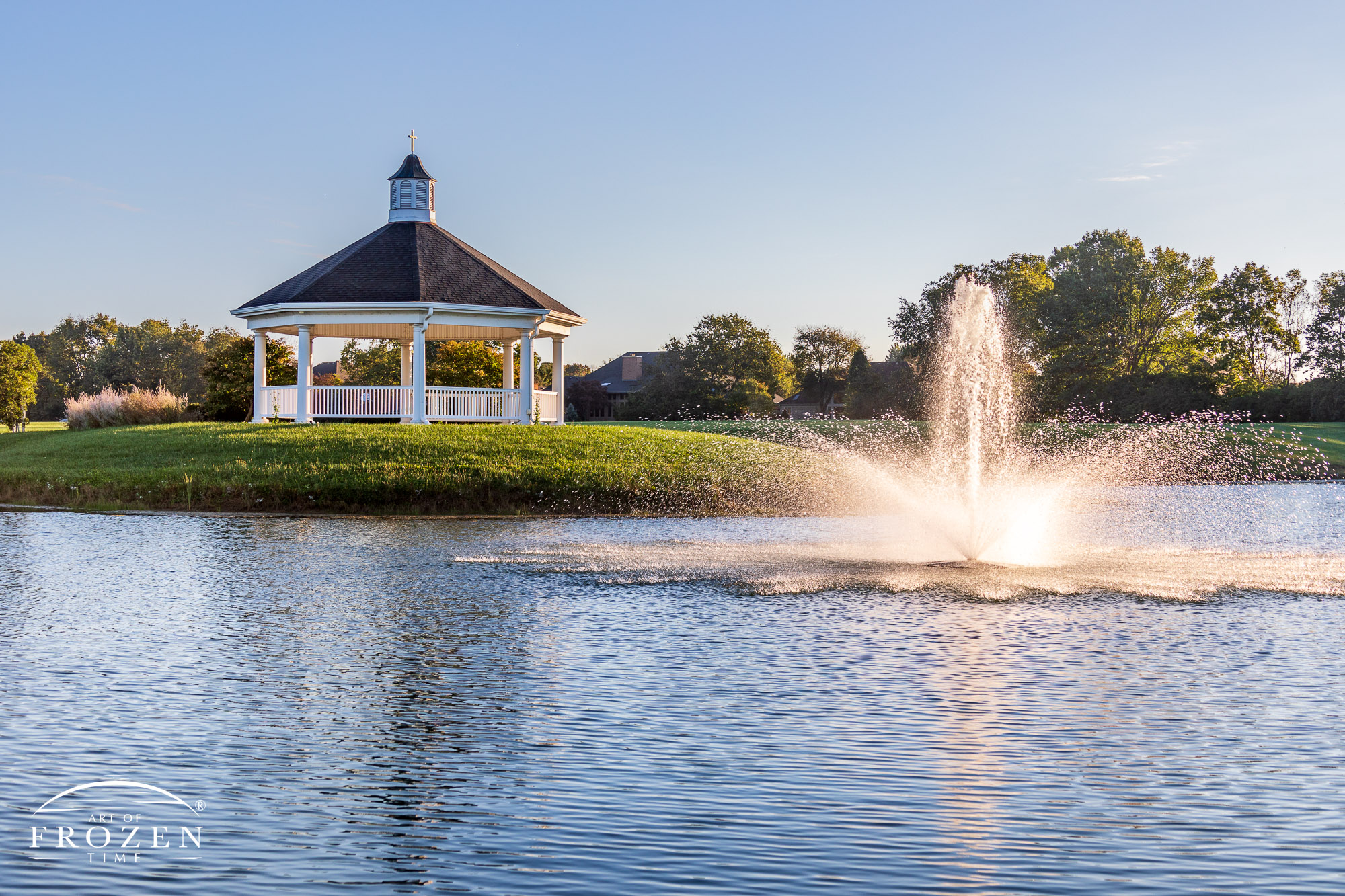 A fountain in Grace Park, Centerville, Ohio, glistens in the morning light as a gazebo resides in the background