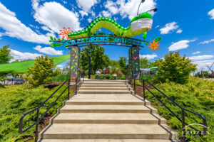 A set of stairs leads visitors under 12' long and colorful worm which welcomes visitors to a local park for kids.
