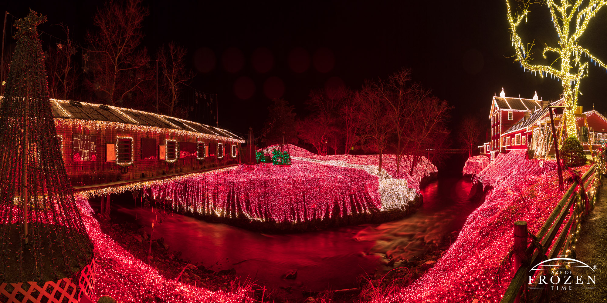 A nightscape of a water-power grist mill surrounding gorge decorated in 4 million, red and white Christmas lights