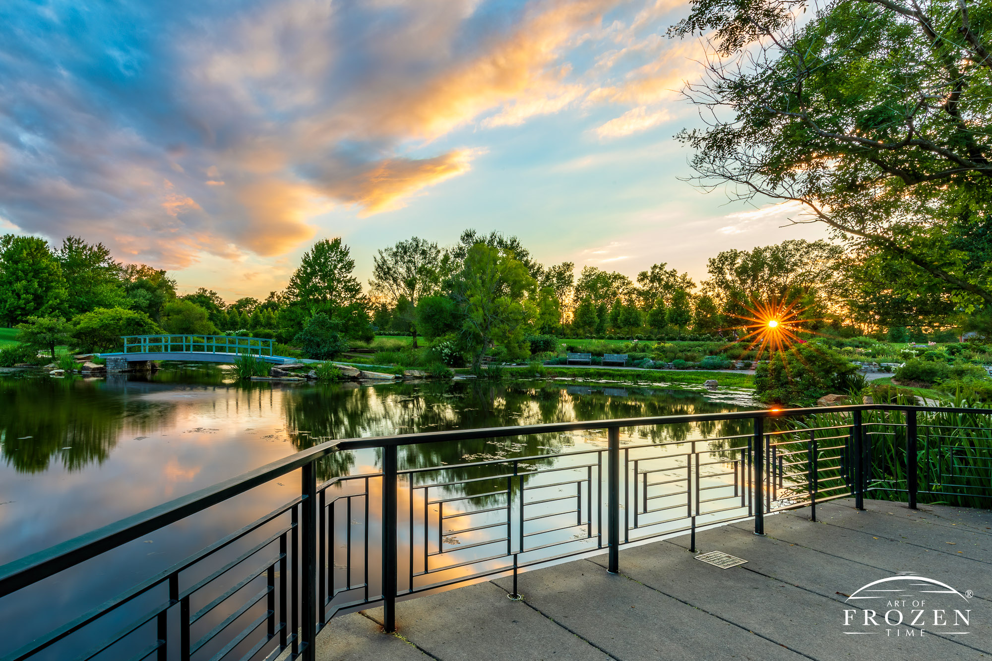An evening view of Cox Arboretum MetroPark’s where the Money Bridge crossed the Water Garden as the park’s trees filter the setting sun