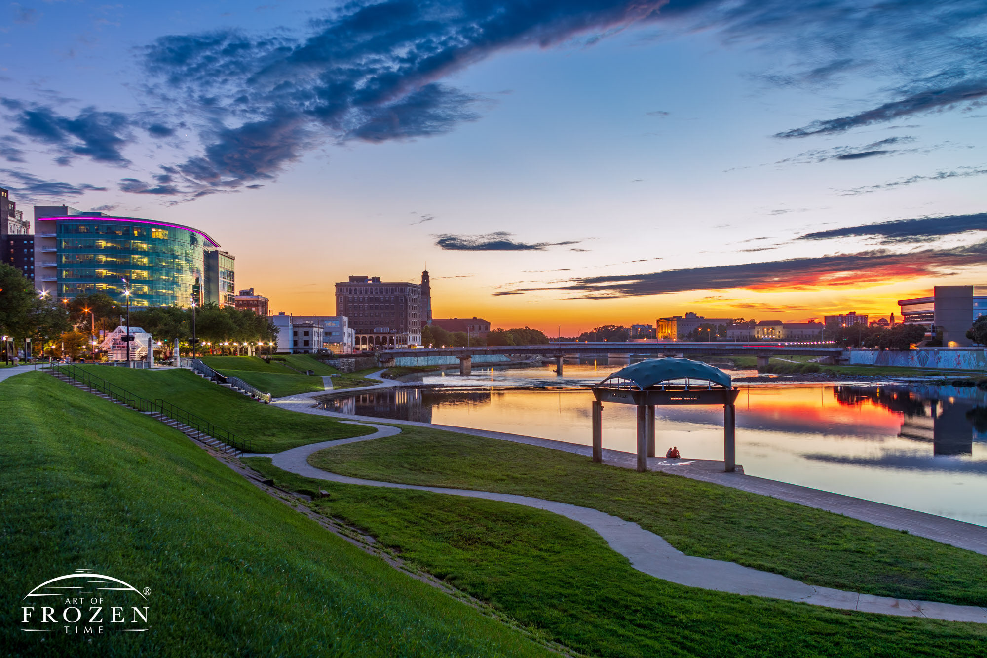 Dayton couple relaxing under the RiverScape Founders Point pavilion watching the Miami River gently pass by as sunset yields to twilight.