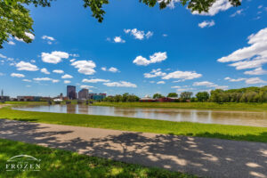 The Great Miami River flowing by Deeds MetroPark as cumulus clouds float though the blue sky