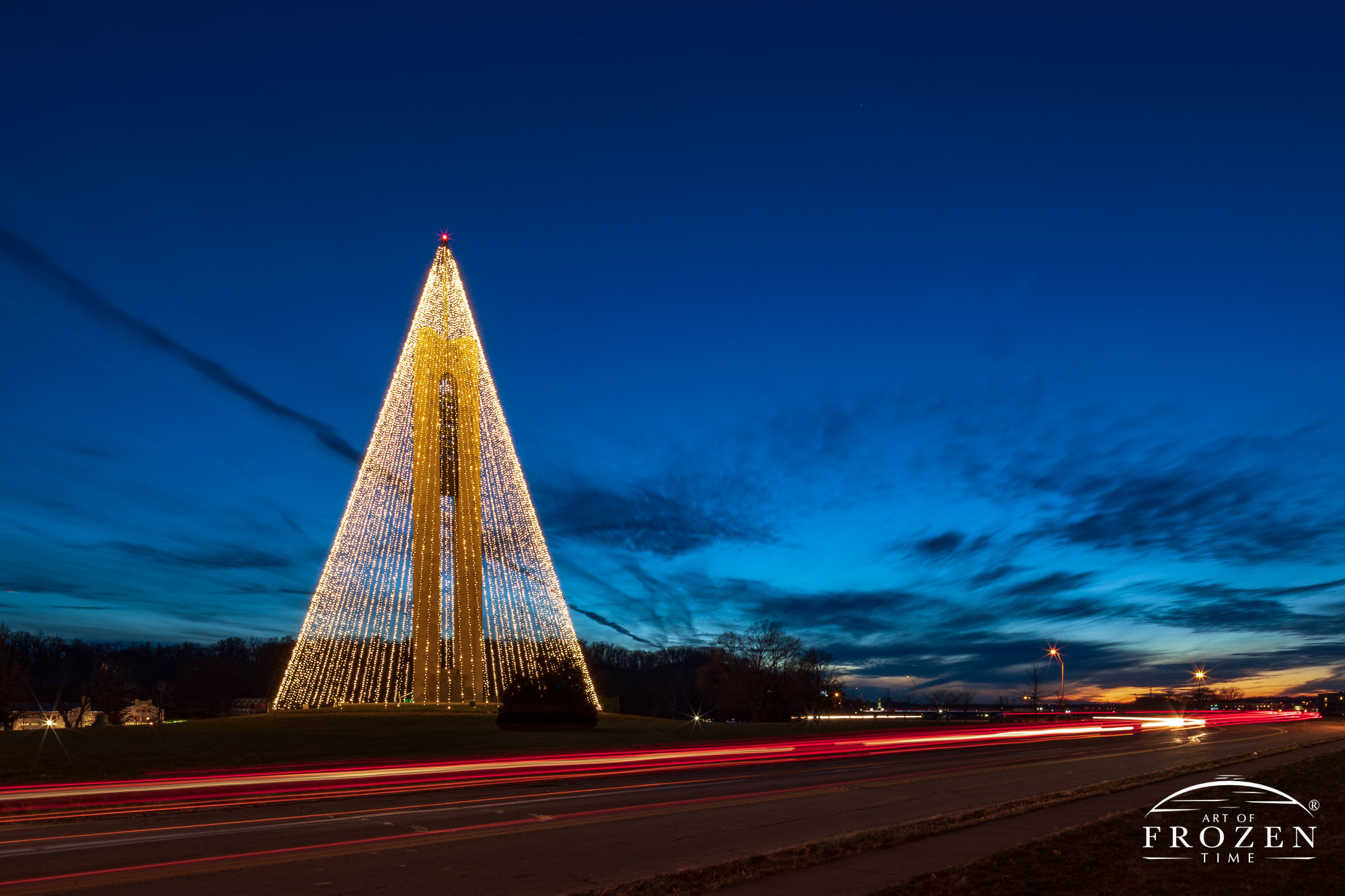 The Deeds Carillon Christmas Tree glows in the deep twilight scene where the long exposures renders traffic as light trails
