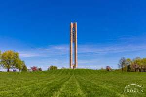 Dayton's bell tower on a spring day where rows of cut grass lead the eye towards the carillon