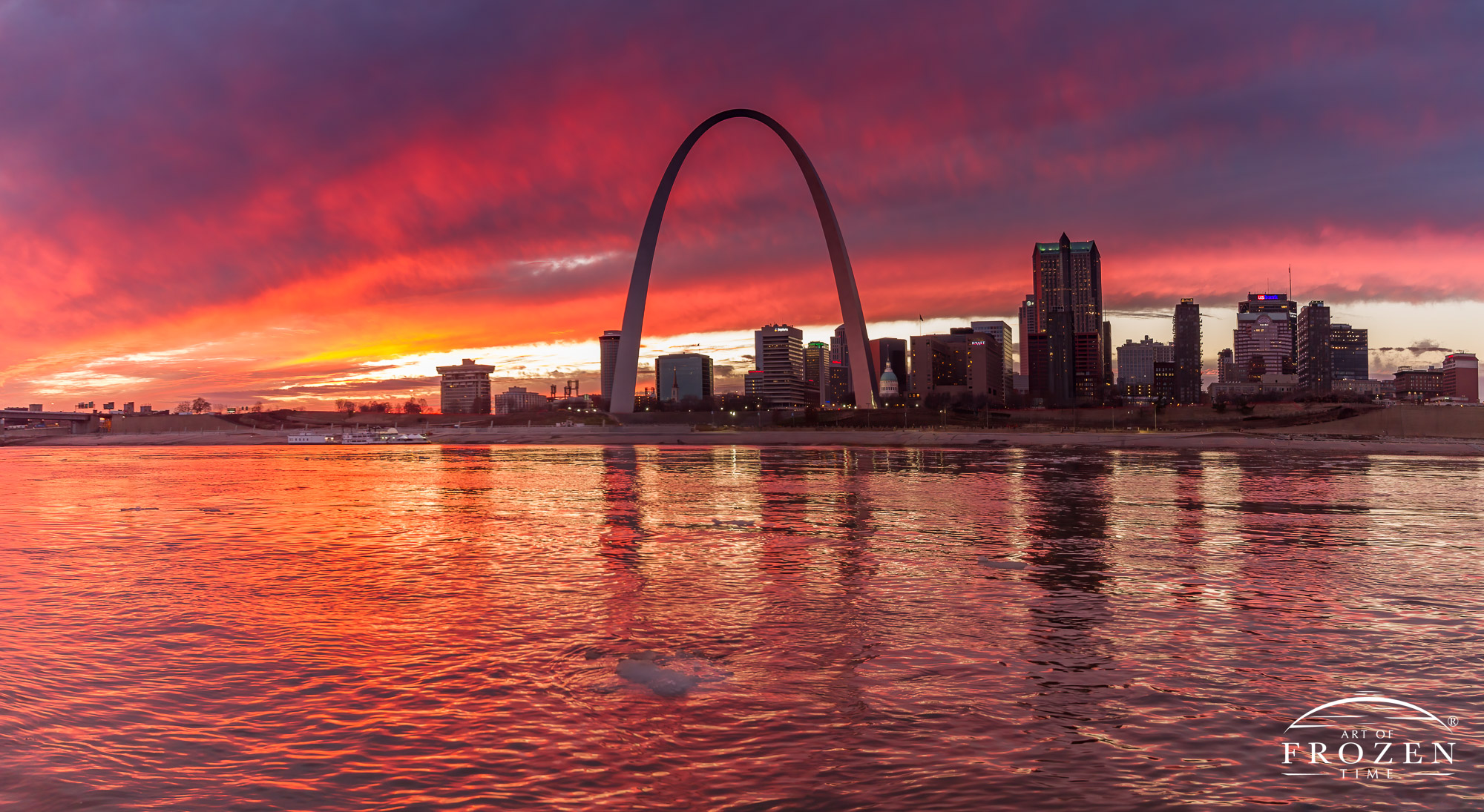 A fiery sunset over St Louis Missouri as captured across the Mississippi River which carries ice flows and reflects the St Louis skyline