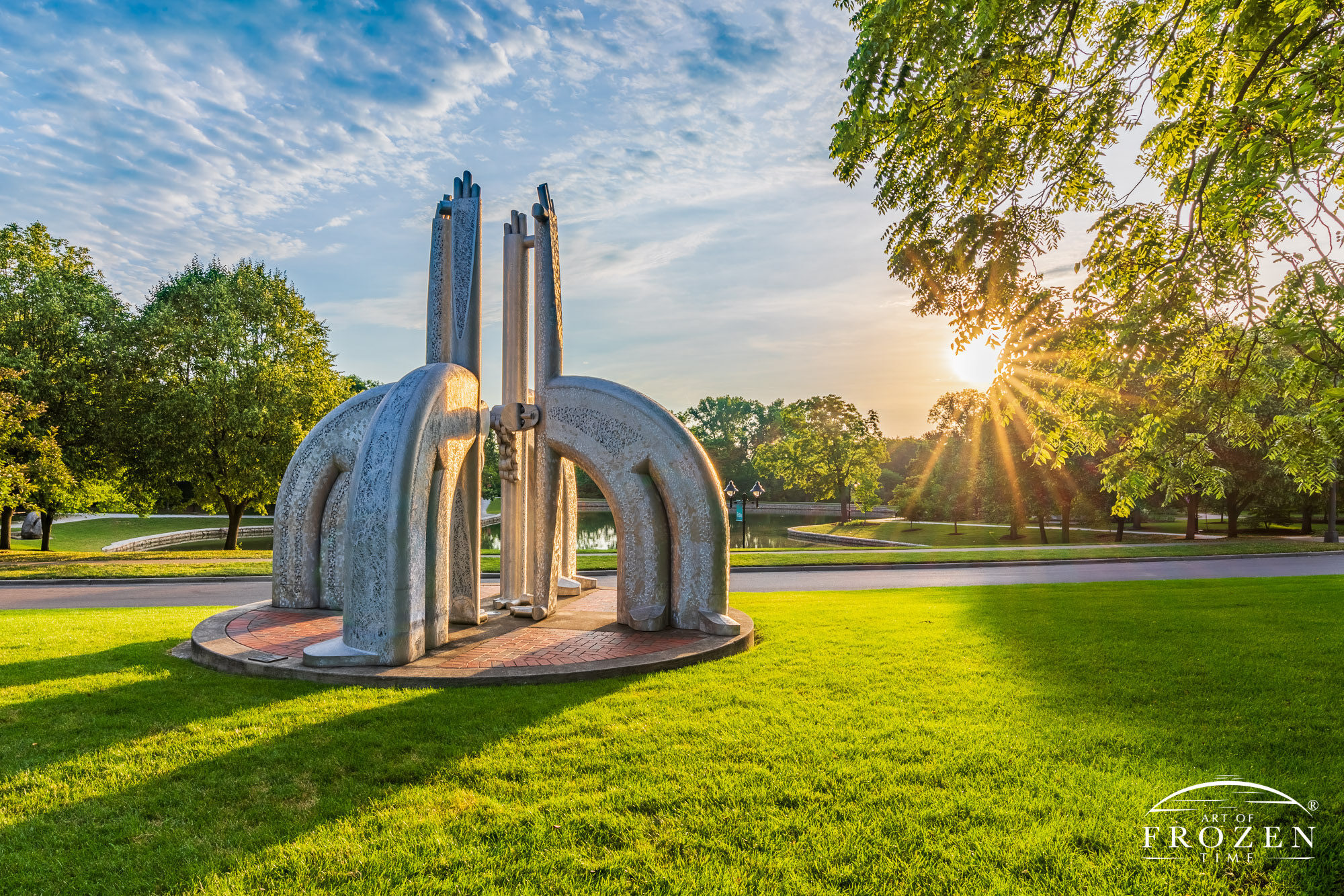 An aluminum sculpture featuring for fanciful figures bask in the golden light on this summer morning in Kettering Ohio’s Lincoln Park