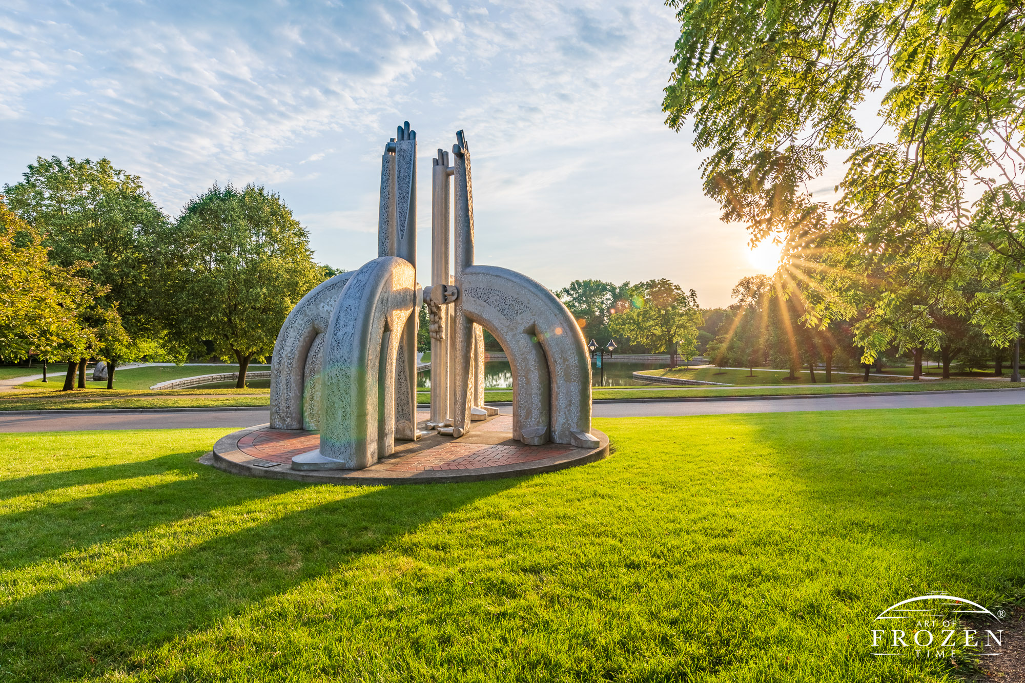 An aluminum sculpture featuring for fanciful figures bask in the golden light on this summer morning in Kettering Ohio’s Lincoln Park