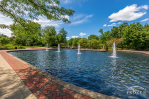 A peaceful park scene where the Fraze Pavilion Fountains dance under blue skies while filling the park with soothing sounds of splashing water
