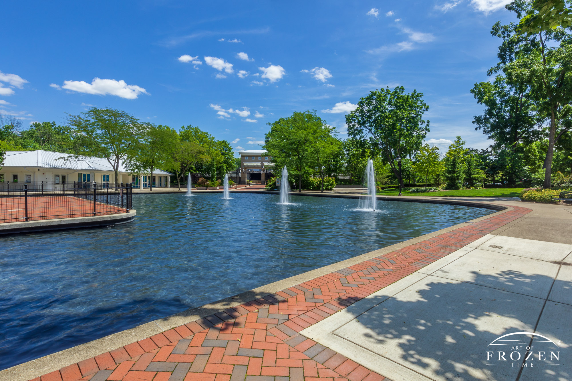 A peaceful park scene where the Fraze Pavilion Fountains dance under blue skies while filling the park with soothing sounds of splashing water