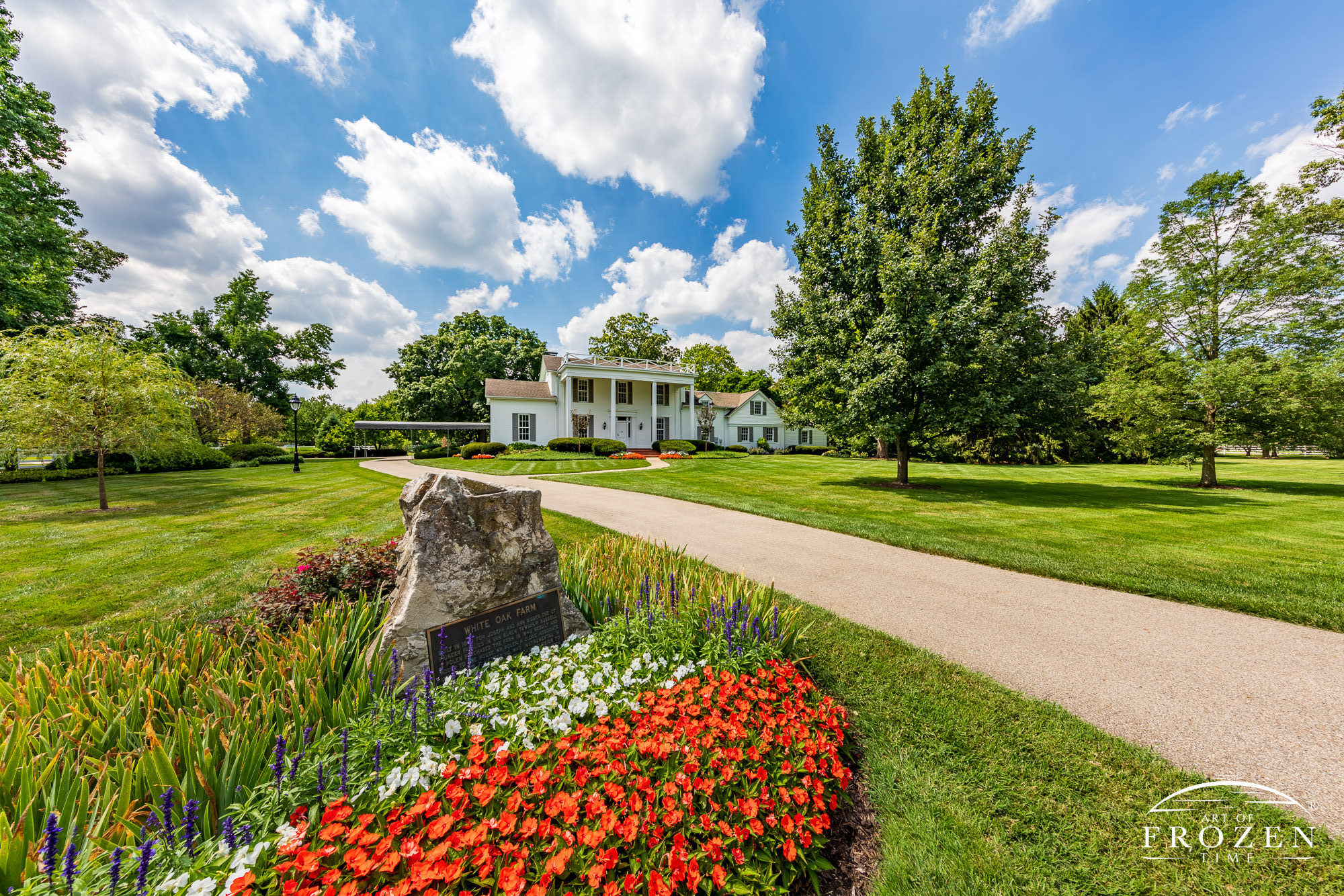 The long driveway to Polen Farm in Kettering Ohio leads the viewer towards the historic farm house on a sunny day