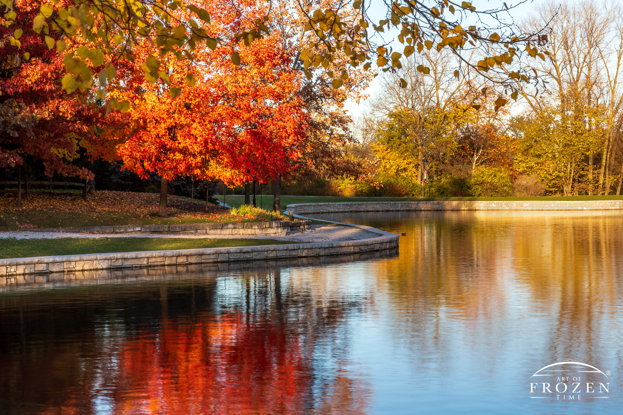 As autumn at peak color around Kettering’s Lincoln Park Pond, the setting sun painted the scene in golden light
