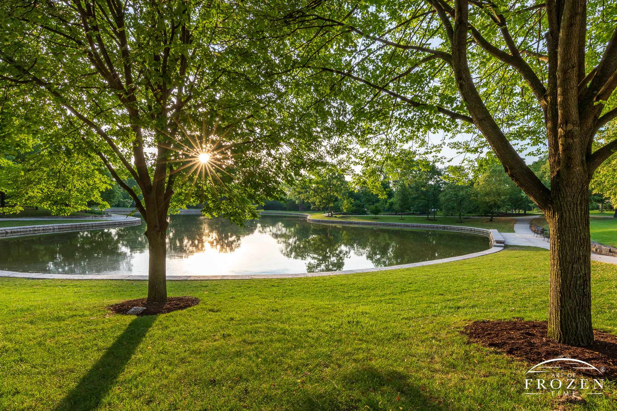 A summer sunrise over Kettering Ohio's Lincoln Park where the surrrounding trees gently filter the morning light