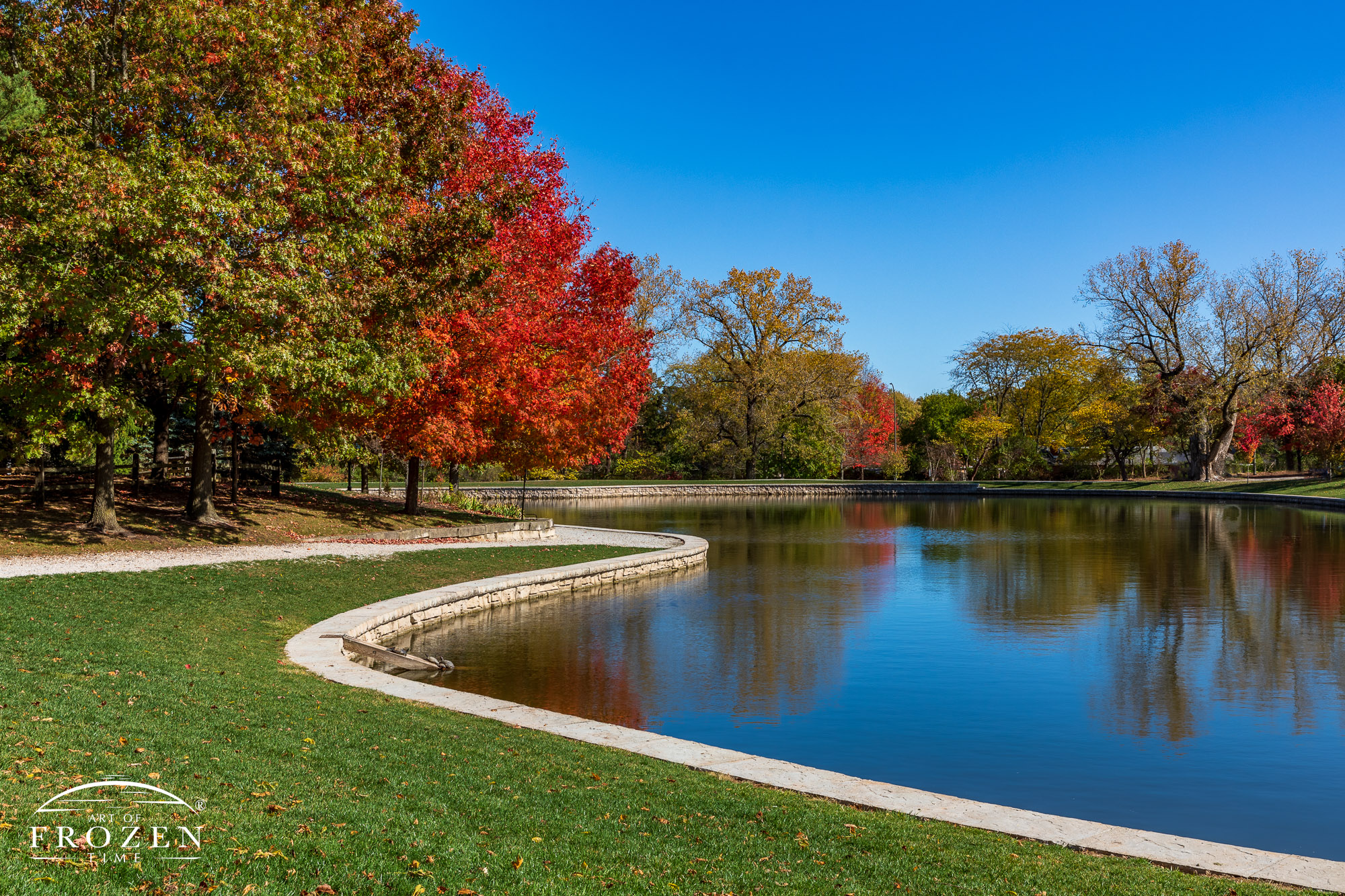 Under burning blue skies, Kettering’s Civic Park Commons displays impressive fall colors as the pond wall leads the viewer into the scene