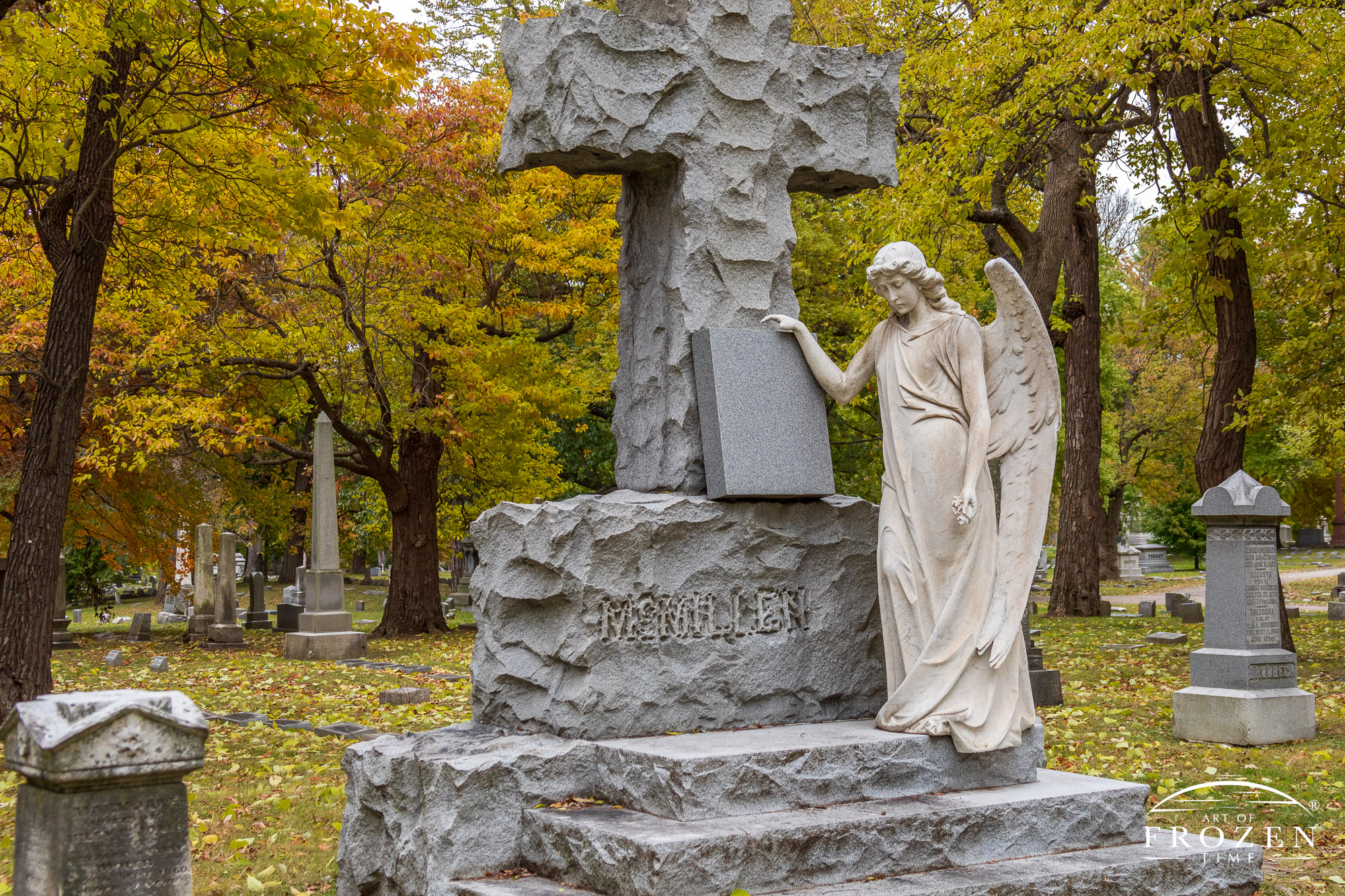 An autumn view of Woodland Cemetery’s McMillen Angel where the contemplative white marble angle appears to have just wiped the family slate clean