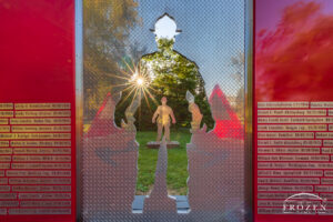 A close view of the Miami Valley Firefighters Memorial in Stubbs Park where the evening sun shines through the firefighter silhouitte