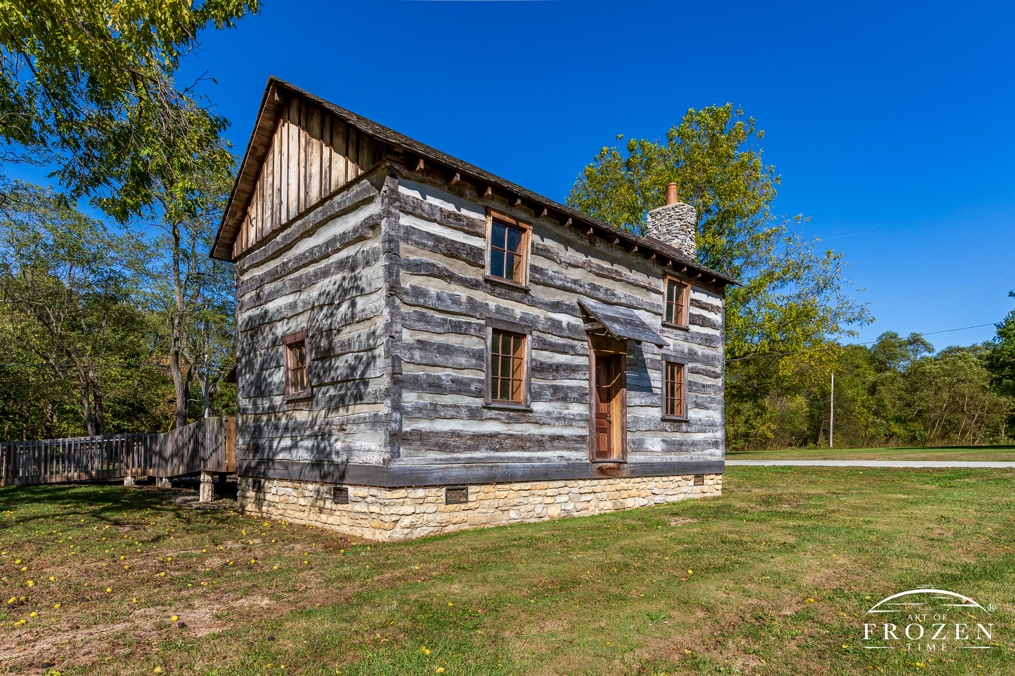 A renovated log home near Cedarville, Ohio basking in the evening sunlight under blue October skies