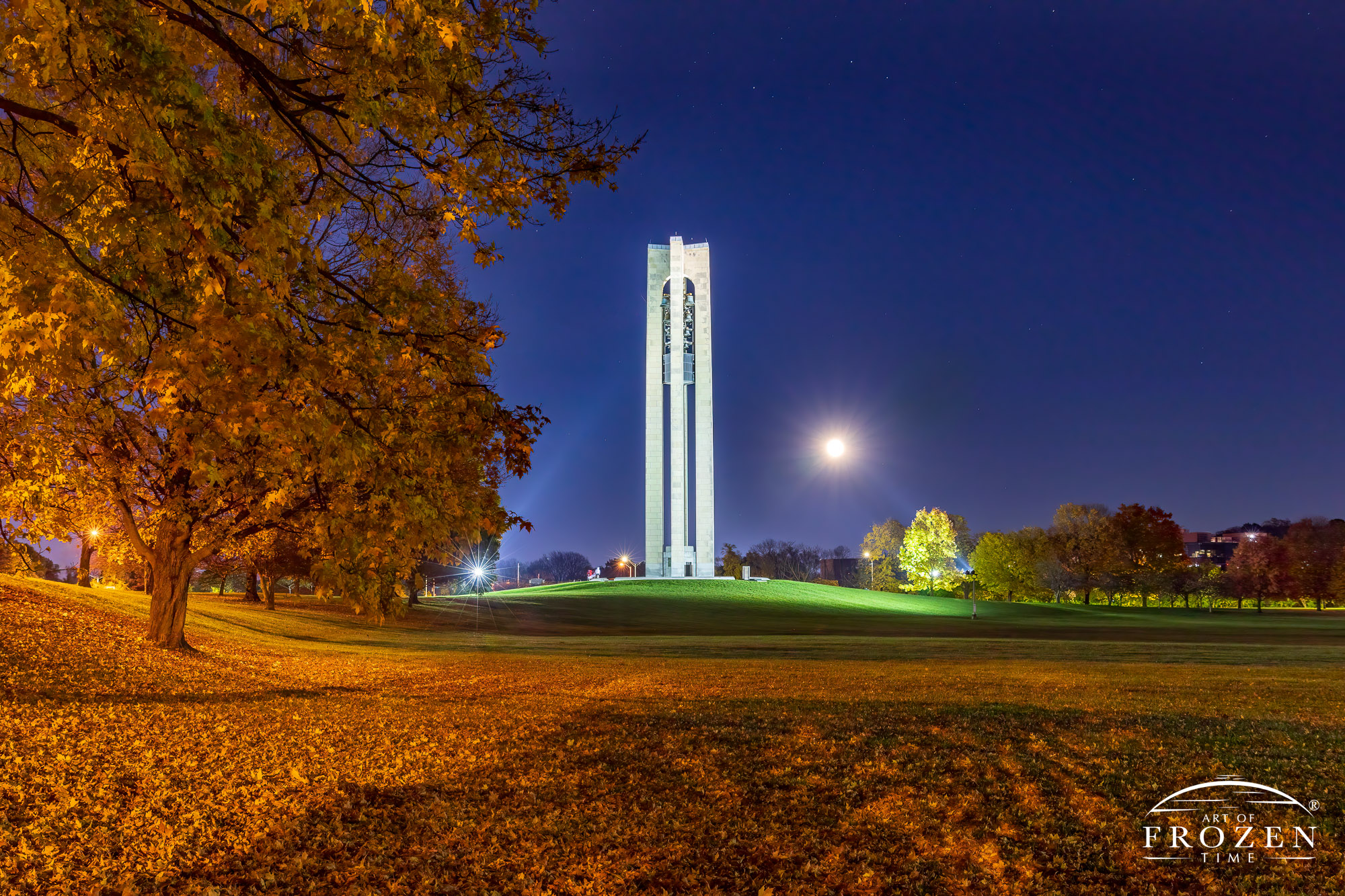 A full moon rising next to Dayton’s bell tower on an autumn evening which coincides with Halloween.