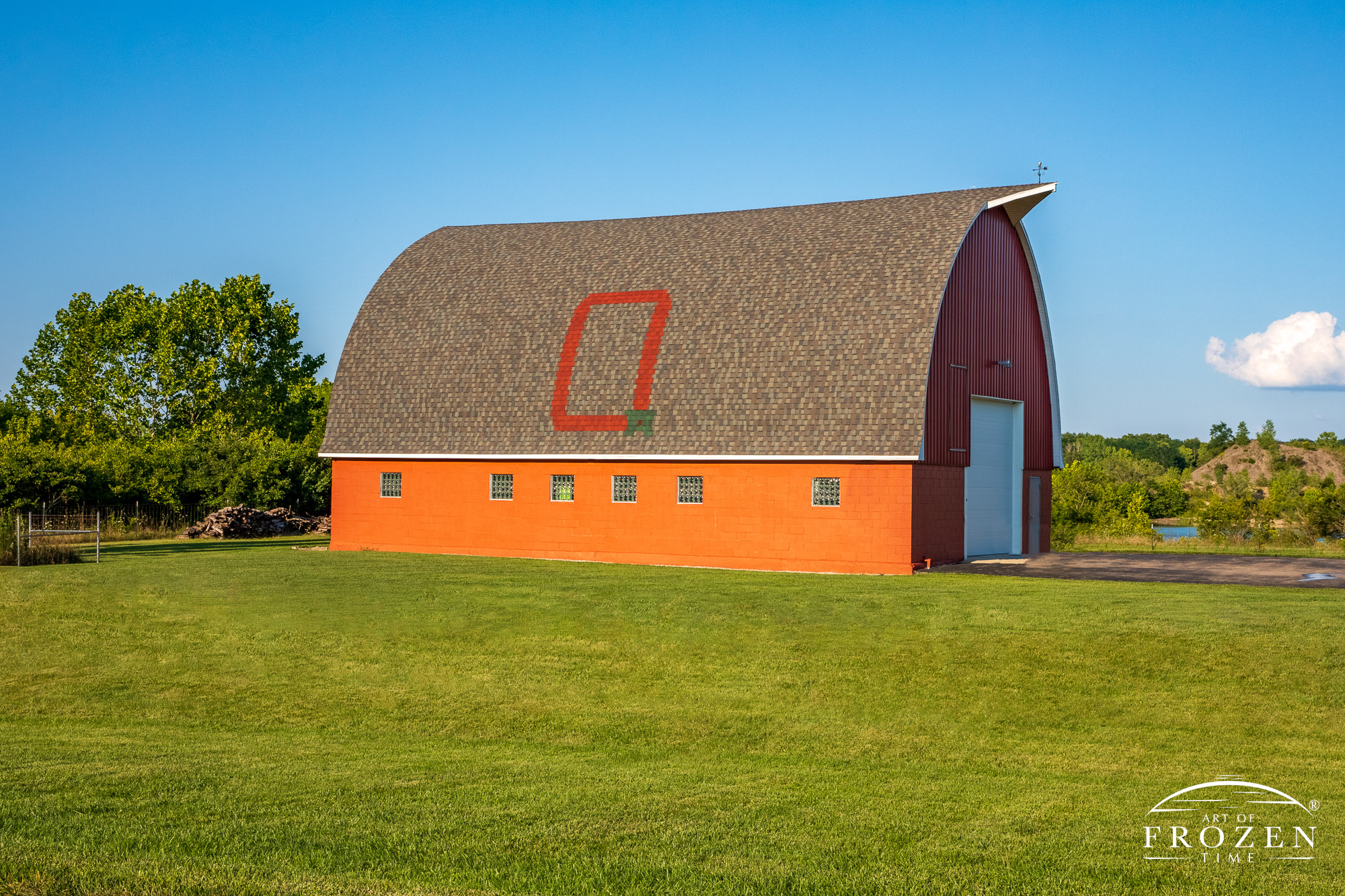 A gothic arch barn whose shingles display a large O for Ohio and classic buckeye leaf that's basking in the golden evening light