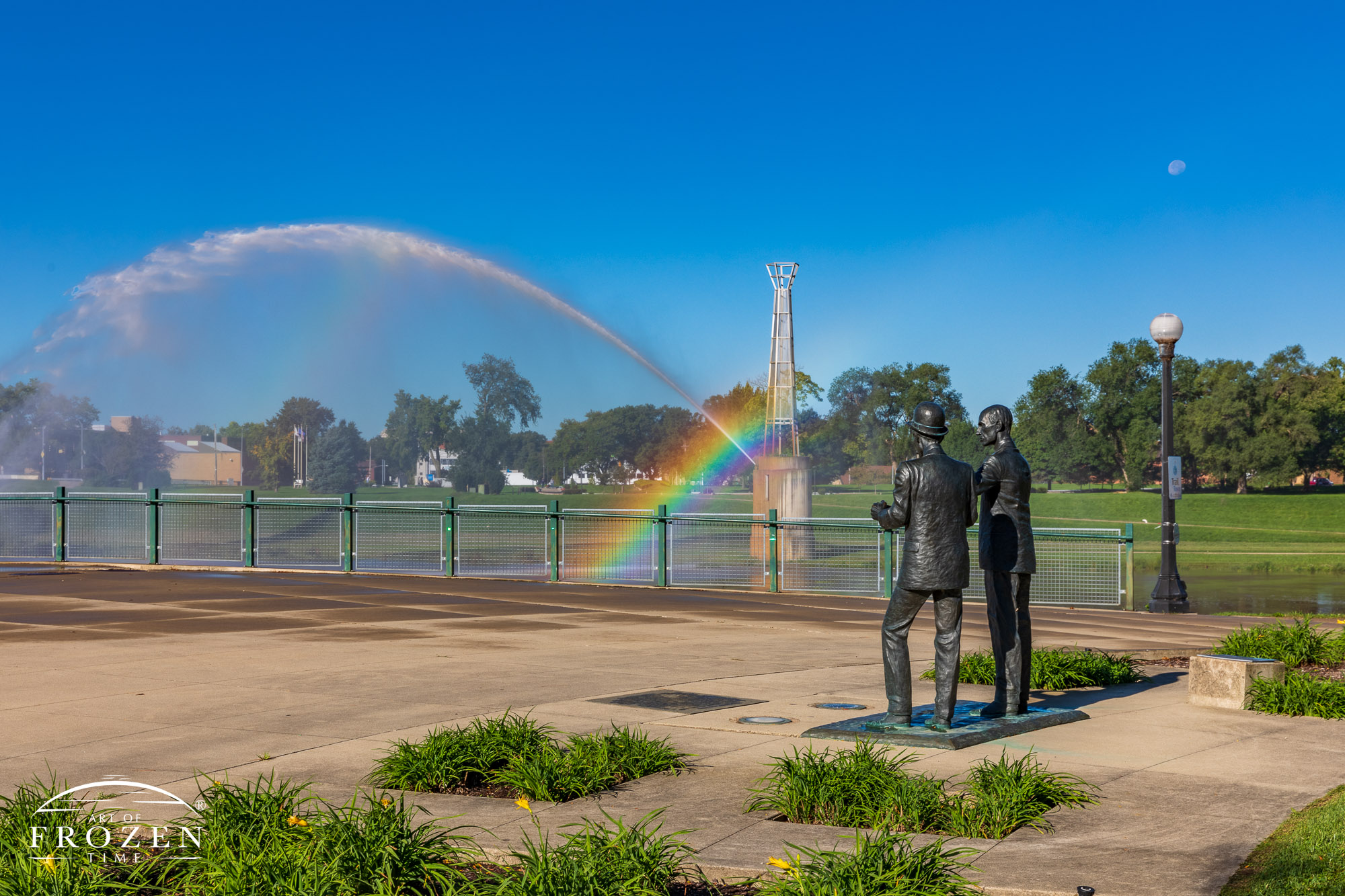 Life-size sculpture of the Wright Brothers depicts them in conversation in front of the Dayton Fountains as the spray creates vivid rainbows