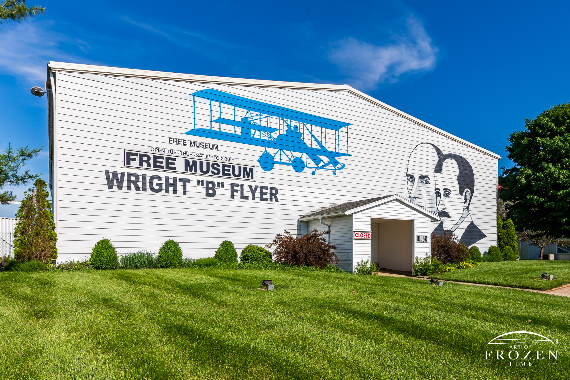 Mural of the Wright Brothers and their Wright B Flyer on a June evening