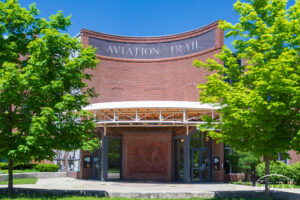 An image of the front of the red-bricked Wright-Dunbar Interpretive Center, under burning blue skies of a perfect May Day